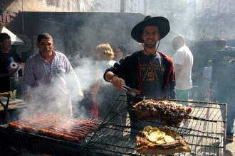 A picture of me behind an asado with chorizo and bife in the barrio de San Telmo in Buenos Aires..