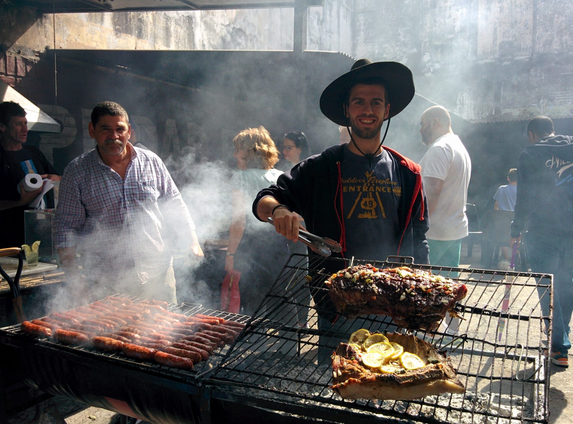 A picture of me behind an asado with chorizo and bife in the barrio de San Telmo in Buenos Aires..