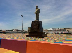 The statue of Benito Quinquela Martín on a multicolored ground.