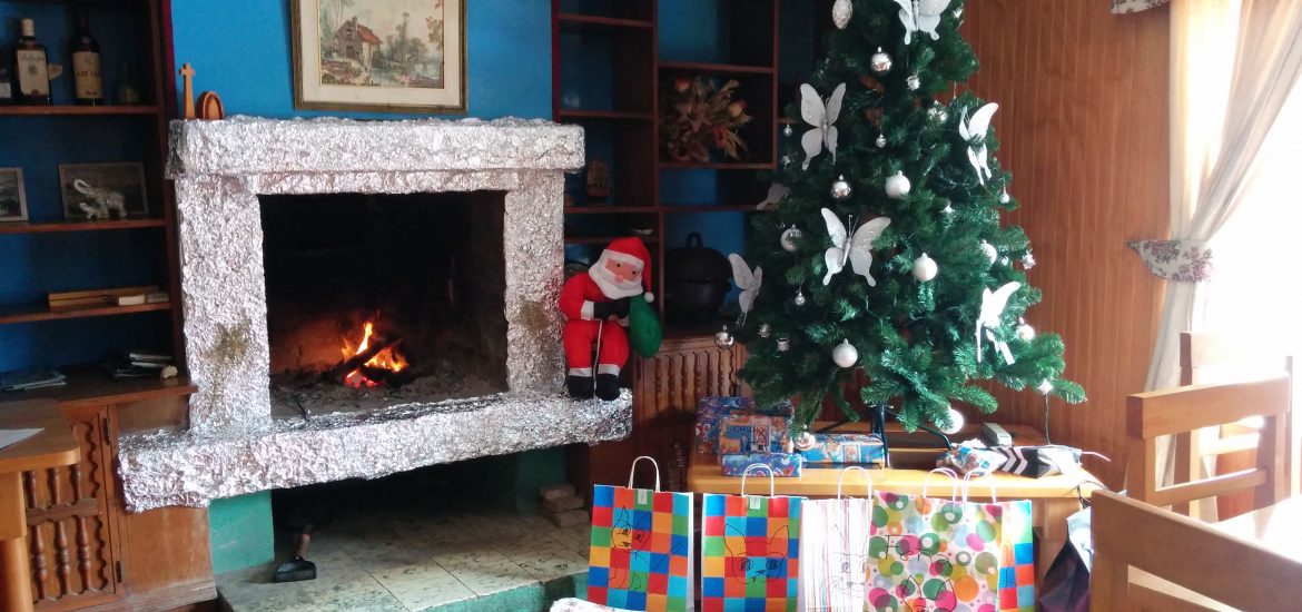 A fireplace with a Christmas tree and gifts.