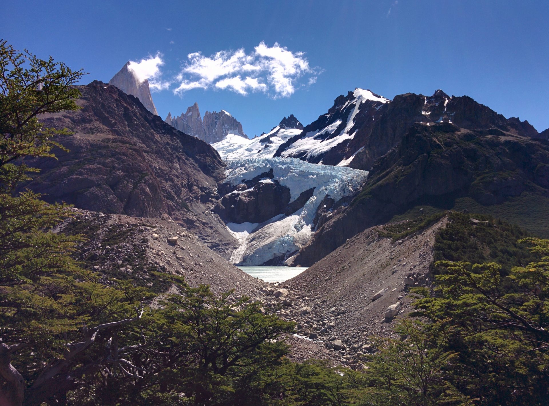 A glacier coming from the moutains behind a vallley.