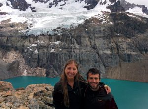 Two people in front of a lake and a mountain