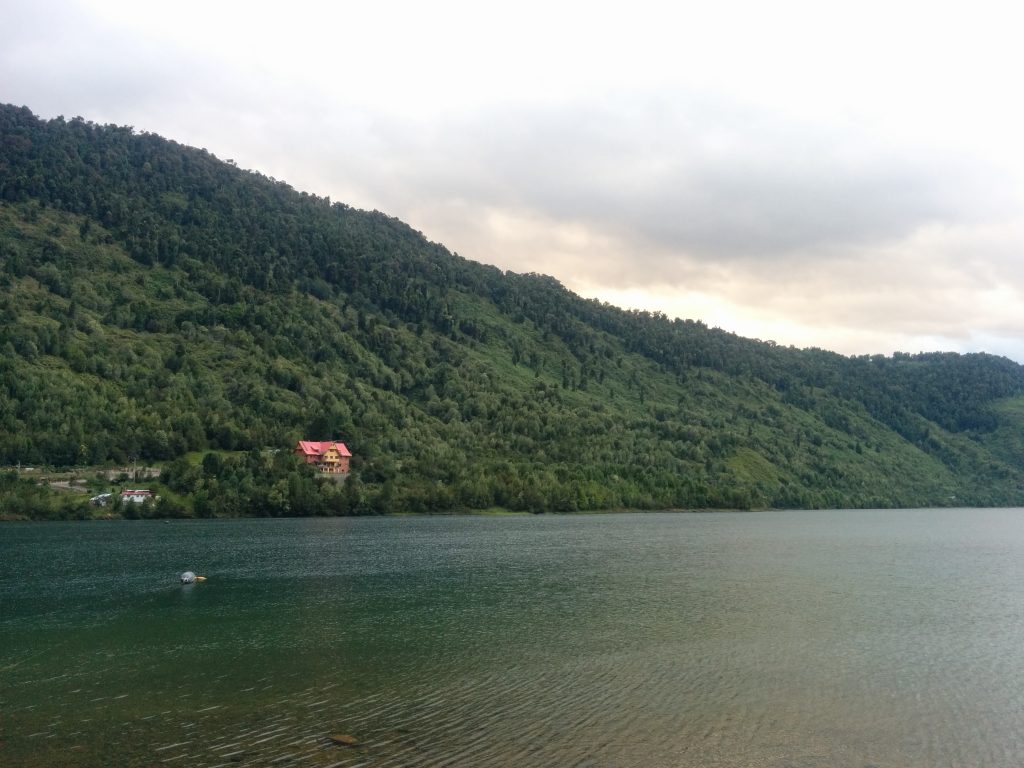 A lake in front of mountains with a grey sky