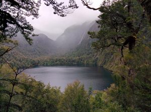 A lake surrounded by forests and mountains.