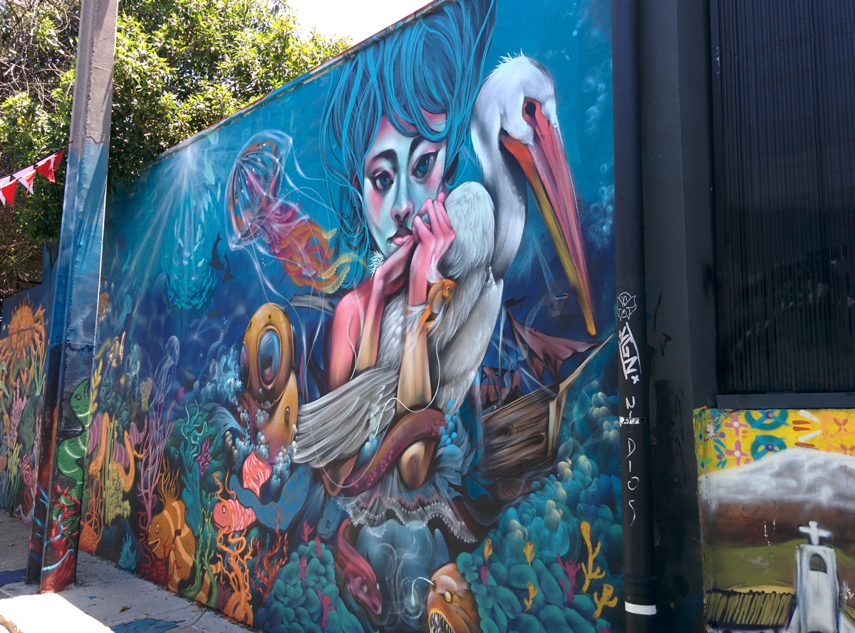 Graffiti representing a girl with a bird under the sea.