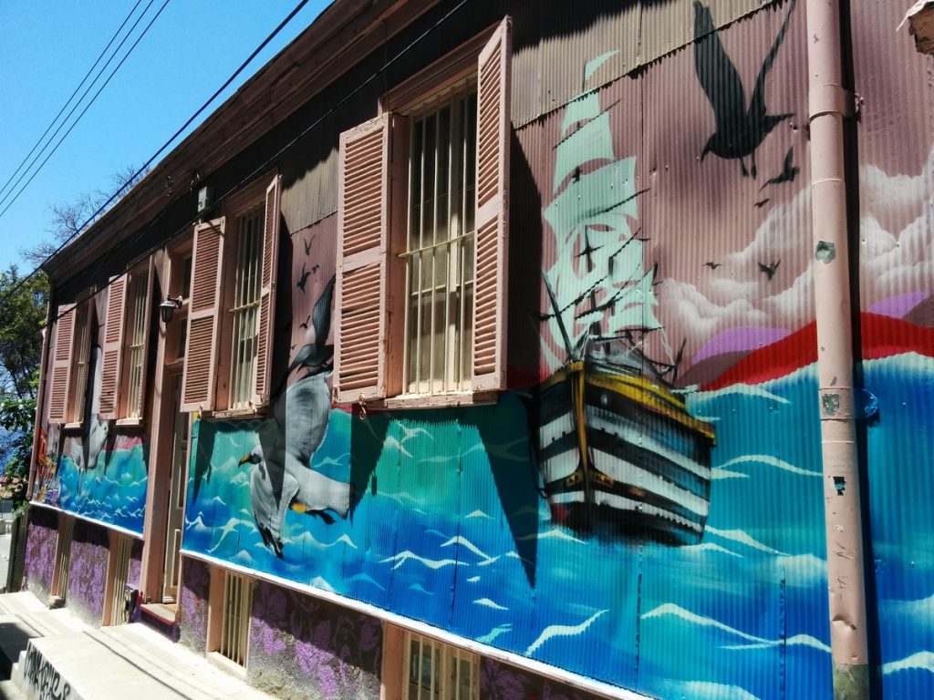 Graffiti on a house representing the sea with boats.