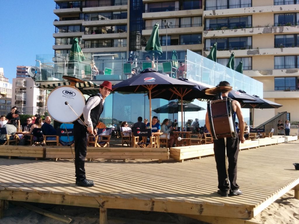 Two dancers and musicians performaing drums