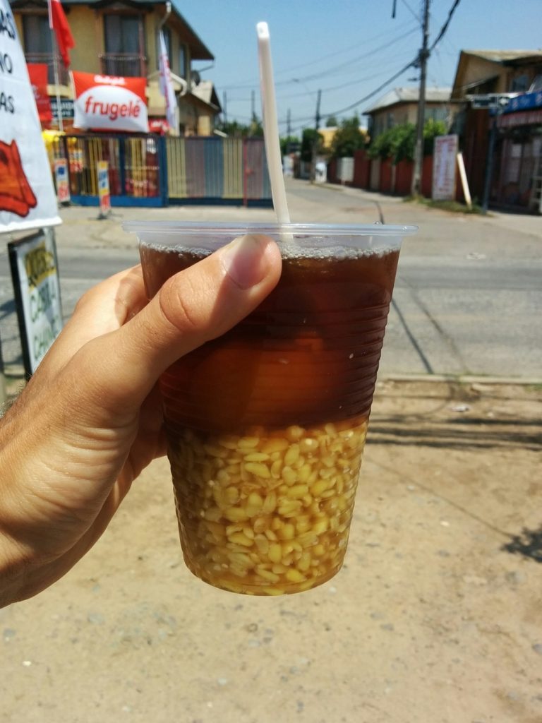 A beverage with cooked wheat, peaches and the juice.